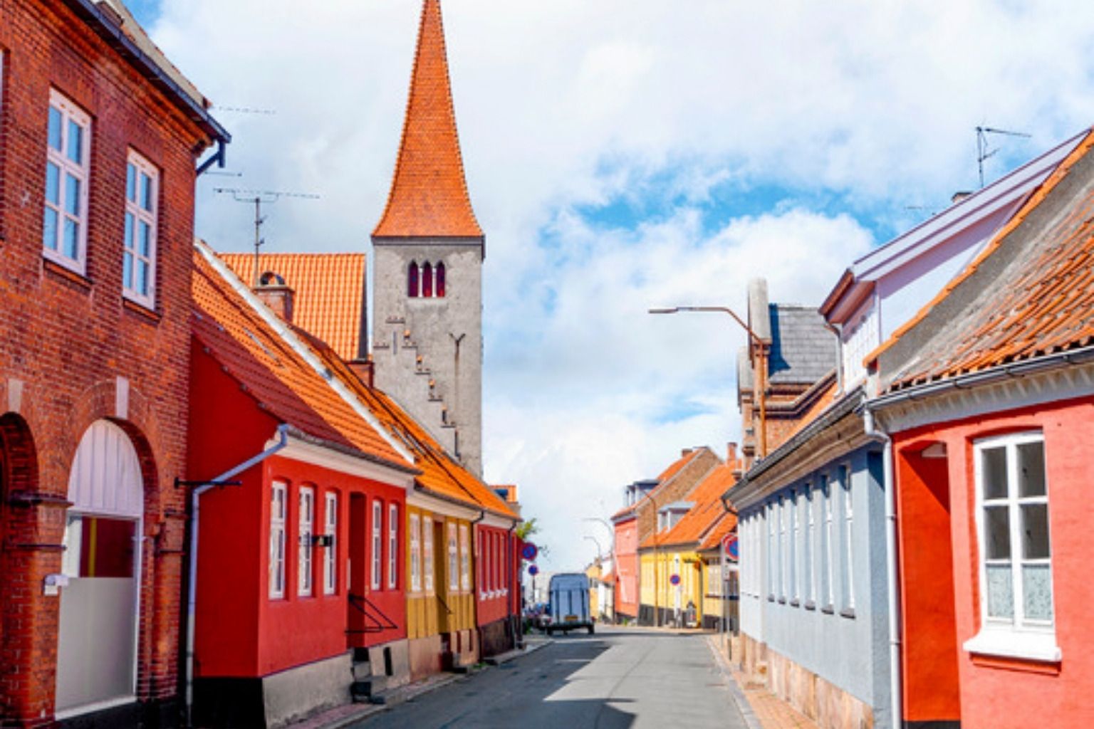 Dansk landsbygade med farvede huse og kirketårn